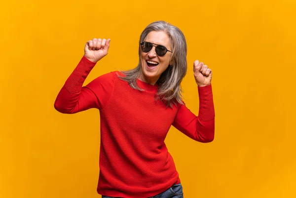 Horizontal portrait of hilarious senior woman in sunglasses dancing isolated. Middle-aged gray-haired lady celebrating holidays — Stock Photo, Image