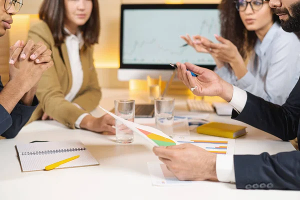 Lieto di sentirlo. Ritratto di giovane manager ottimista qualificato sta guardando i suoi colleghi mentre si siede a tavola e ha una piacevole comunicazione. Uomo che tiene i diagrammi — Foto Stock