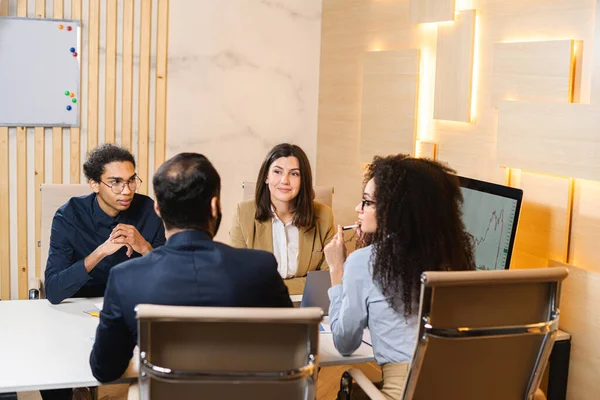 Travailler dur pour gagner. Quatre jeunes collègues discutent de documents pour une présentation commerciale tout en travaillant au bureau de création. Entreprises — Photo