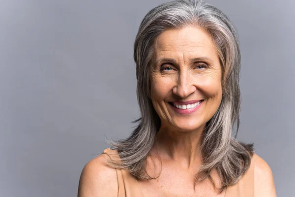 Encantadora anciana sonriente aislada sobre fondo gris — Foto de Stock