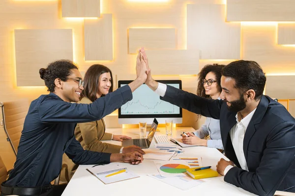 Full length side view outgoing businessmen giving high five while working with notebook computers at desk. Glad males during labor with technology — 스톡 사진