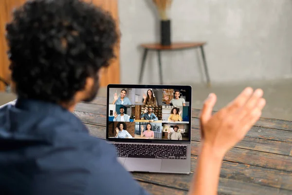 Männlicher Mitarbeiter beteiligt Video-Meeting auf dem Laptop mit vielfältigem Arbeitsteam — Stockfoto