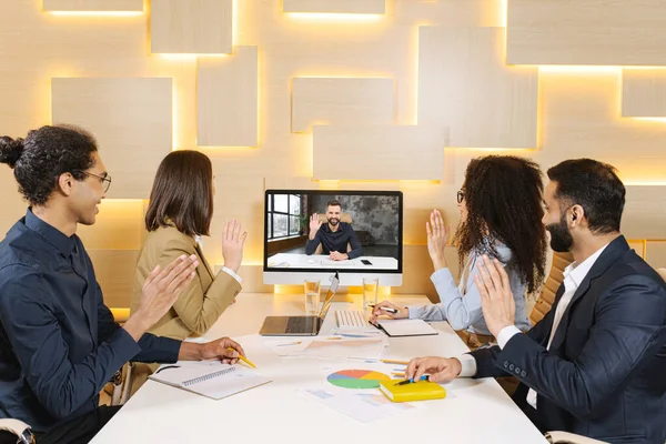 Dream team. Group of young and active multiracial people are having a discussion in office atmosphere with their colleague via video call — Foto Stock
