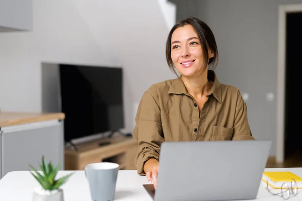 Inspired young Asian multiracial woman sitting at the desk at home office — стокове фото