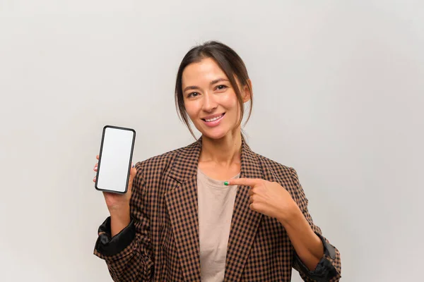 Retrato de mujer de negocios asiática sonriente positiva mostrando teléfono inteligente con pantalla en blanco — Foto de Stock