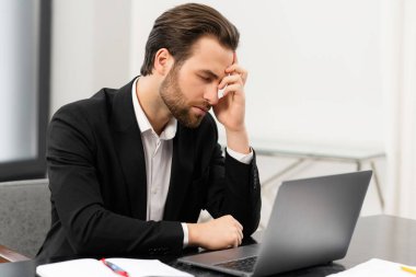 Tired male office employee suffering from strong headache
