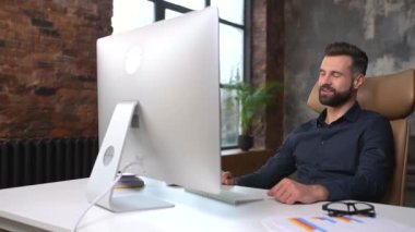 Male office employee using computer app for video connection with colleagues on distance