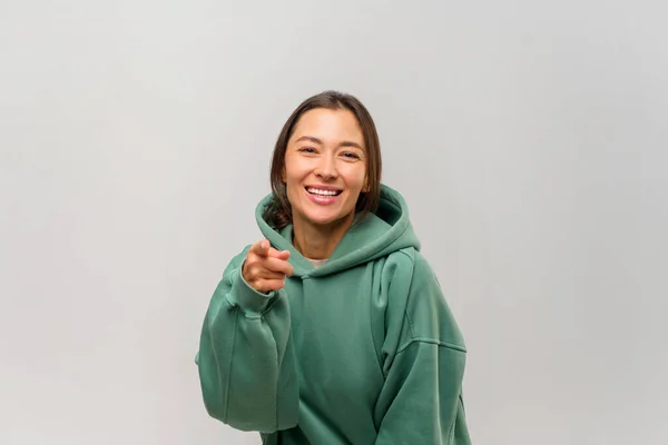 Feliz mujer satisfecha con el pelo castaño señalándote con los dedos mirando a la cámara con una sonrisa dentada, felicitándote con la victoria. Estudio interior plano aislado en blanco — Foto de Stock