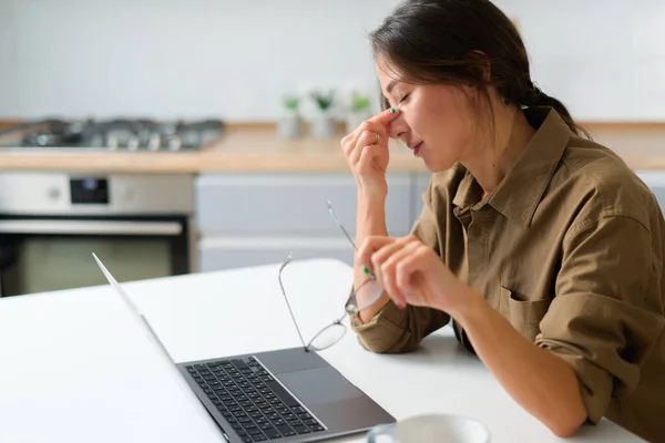 Asian woman or student closed her eyes and massaging her nose, suffering from severe headache migraine. Tired young woman overwhelmed with computer — Fotografia de Stock