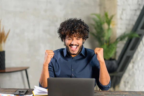 Excited Pakistani businessman looking at the laptop screen and rejoicing. Guy screaming yes staring with mouth opened at monitor amused with unexpected opportunity — Stockfoto