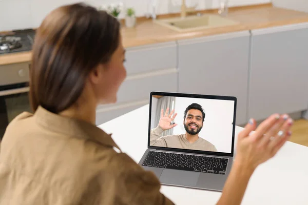 Primer plano de la mujer asiática con el pelo largo utilizando la aplicación para la comunicación de vídeo a distancia con su compañero de trabajo, amigo, reunión en línea, mirando y saludando en el escritorio portátil con perfil masculino — Foto de Stock