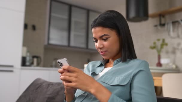 Çok mutlu bir kadın telefon ekranına bakıyor, başarıyı kutluyor. — Stok video