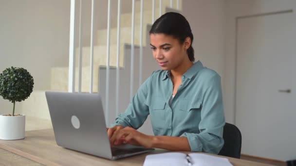 Fröhliches Mädchen mit gemischter Rasse nutzt Laptop für Fernarbeit — Stockvideo