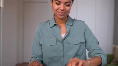 Heyecanlı gülümseyen etnik kadın dizüstü bilgisayarla çalışıyor.