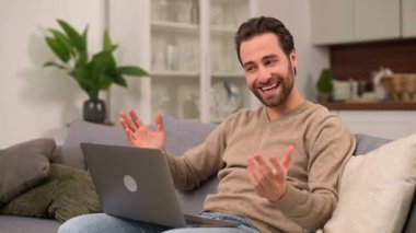 Video bağlantısı için dizüstü bilgisayar kullanan neşeli kaygısız adam.