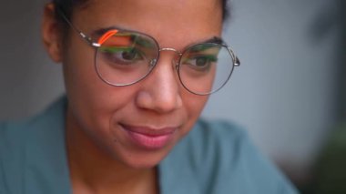 Gözlüklü bayan öğrenci lenslerde bilgisayar, titreşim ve yansıma kullanıyor.