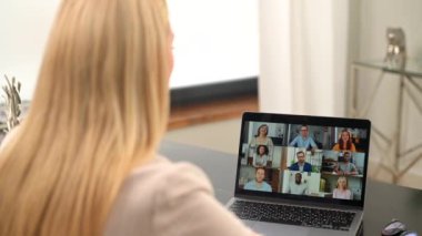 Çalışanlarla video görüşmesi yapan kadının arka planı