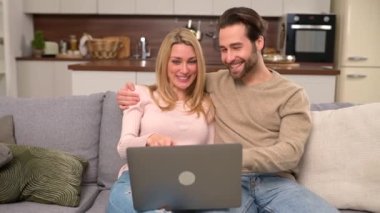 Huzurlu çift evde birlikte vakit geçiriyorlar, dizüstü bilgisayarlarını bir şey için kullanıyorlar.