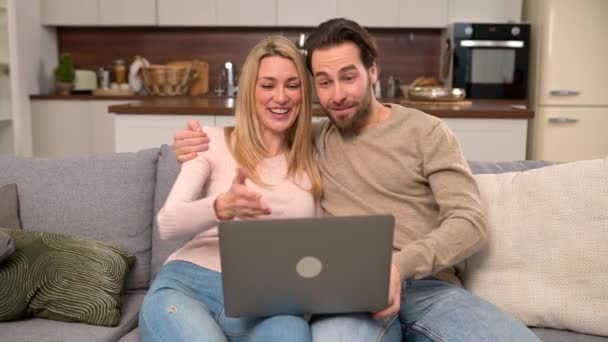 Βιντεοκλήση με φίλους. Χαρούμενο παντρεμένο ζευγάρι που χρησιμοποιεί φορητό υπολογιστή για σύνδεση βίντεο — Αρχείο Βίντεο