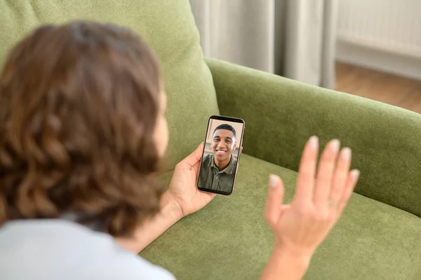 Σύνδεση βίντεο στην απόσταση. Θετική νεαρή γυναίκα που χρησιμοποιεί smartphone για βιντεοκλήση με τον φίλο. Χαμογελώντας θηλυκό έχει ευχάριστη online chat, ενώ βρίσκεται στον καναπέ — Φωτογραφία Αρχείου
