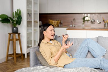 Evdeki kanepede oturan genç ve çekici bir kadın, kaydediyor ve sesli mesaj yolluyor. Cep telefonunda ses tanıma uygulaması kullanan kadın