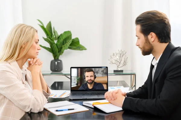 Jovem mulher e homem sentado no laptop, conversando com colega, falando sobre as notícias, trabalho, novo projeto, enquanto trabalhava no escritório — Fotografia de Stock