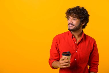 Bir kahve molası ver. Genç hippi, elinde sabah kahvesiyle elinde kağıt bardakla ayakta duruyor. Kapalı, izole, stüdyo çekimi