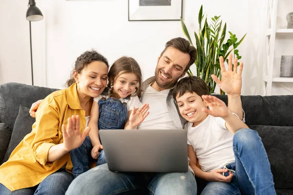 四口之家使用笔记本电脑与祖父母或家人进行视频连接 — 图库照片