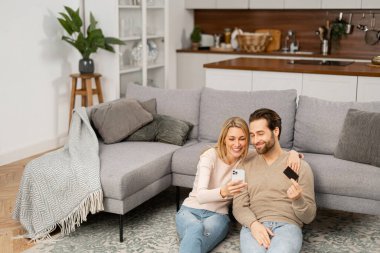 Uzun zamandır beklenen beyaz çift ellerinde akıllı telefon ve kredi kartıyla otururken sevinçten havalara uçuyor.