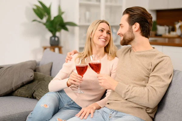 Armonioso coppia sposata con il vino avendo appuntamento romantico, riposo dopo la giornata di lavoro a casa, trascorrere del tempo insieme. Coniugi che celebrano data importante — Foto Stock