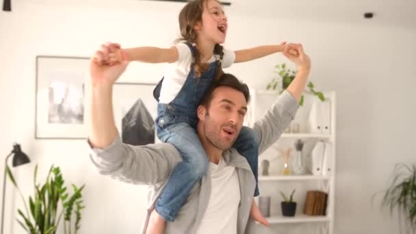 Liefdevolle vader draagt zijn kleine peuter dochter op de schouders — Stockvideo