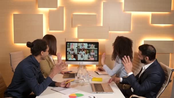 Впевнені бізнесмени сидять за столом з комп'ютером, спілкуються з колегою — стокове відео