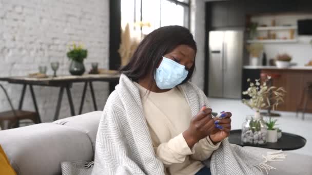 Sjuk upprörd afrikansk-amerikansk kvinna bär mask mäter temperatur s — Stockvideo