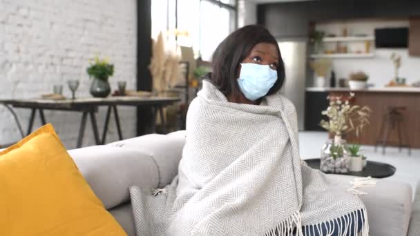 Full length άποψη της νεαρής άρρωστης γυναίκας φορώντας προστατευτική μάσκα προσώπου αισθάνεται άσχημα στο σπίτι — Αρχείο Βίντεο