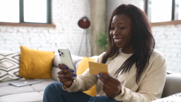 Веселая молодая многорасовая женщина, использующая приложение для покупок смартфонов для покупки онлайн — стоковое видео