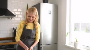 İnternetten yemek yapmayı öğren. Olgun 40 'lı yaşlarda bir kadın yemek pişirme videosu izliyor.