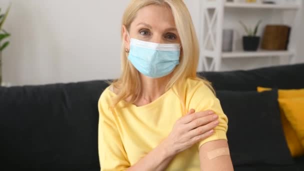 Ανώτερη γυναίκα που δείχνει το χέρι της με επίδεσμο μετά το εμβόλιο του κορωναϊού — Αρχείο Βίντεο