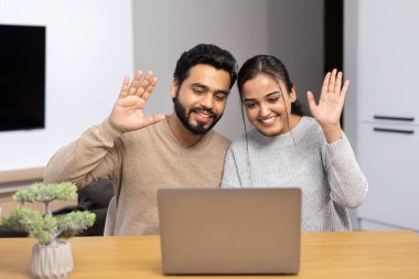Çok ırklı erkek ve kadın web kameralarına selam veriyor, gülümsüyor ve selamlıyorlar. İnternette konuşan ırklar arası bir çift. Laptop 'ta aile ya da arkadaşlarla video görüşmesi yapıyorlar.