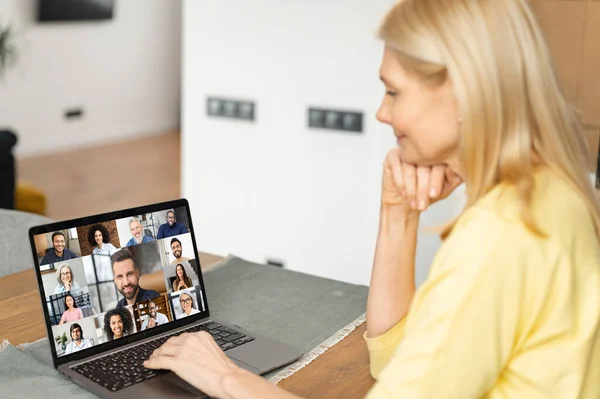 Poranne spotkanie online. Starsza kobieta używa aplikacji na komputerze, aby połączyć się z kolegami, pracownikami. Wideo połączenie z wieloma osobami razem — Zdjęcie stockowe