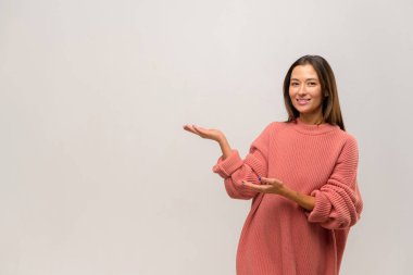 Ticari teklife bak. Neşeli kadın avucundaki fotokopi alanını işaret ediyor, fikir sunumu için boş bir yer, ürün reklamcılığı. Stüdyo içi çekim