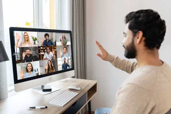 Счастливый и оптимистичный индийский мужчина в повседневной одежде с помощью компьютера в современном офисе, успешный вдохновленный арабский предприниматель мужчина смотрит на экран и задумчиво улыбается — стоковое фото