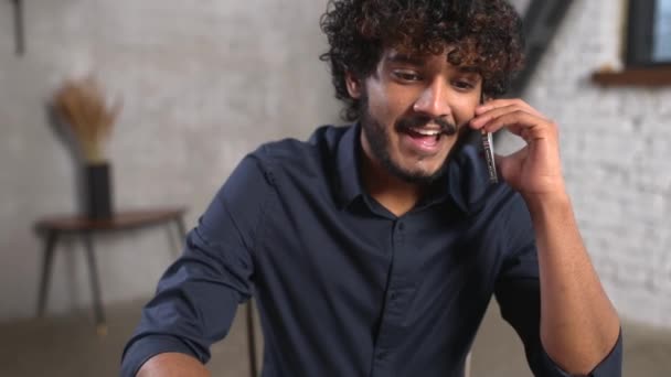 스마트 캐주얼 셔츠를 입고 원거리 작업을 위해 노트북 컴퓨터를 사용하는 바쁜 인도 청년 — 비디오