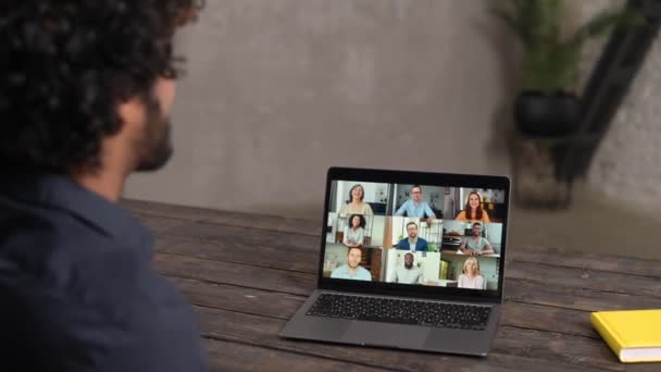 Чоловік співробітник залучив відеозустріч на ноутбуці з різноманітною робочою командою — стокове відео