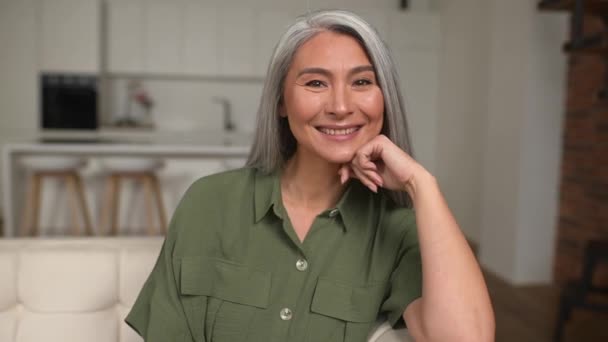 Portret van een aantrekkelijke vrouw van middelbare leeftijd met lang zilver haar in een modern appartement — Stockvideo