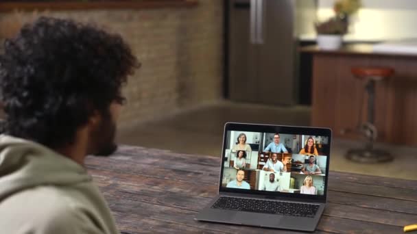 Homem usando aplicativo no laptop para reunião de vídeo com muitas pessoas juntas — Vídeo de Stock