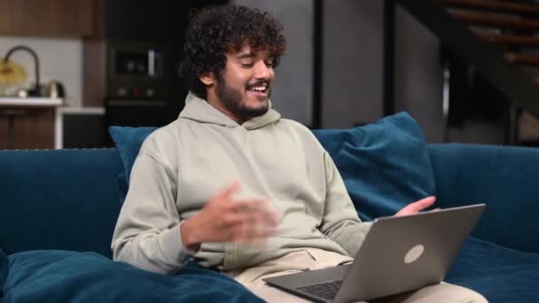 Videogesprek. Vrolijke aantrekkelijke Midden-Oosten kerel is met behulp van laptop voor video communicatie — Stockvideo