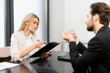 Parlak fikir. Neşeli, nitelikli genç meslektaşlar masada oturmuş projelerini sırıtarak tartışıyorlar. Kadının elinde belgeler var.