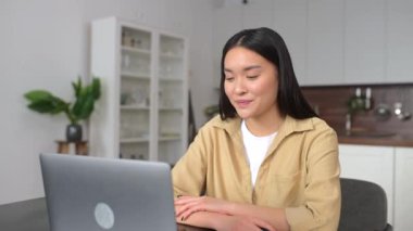 Video call. Asian woman wearing smart casual wear using laptop for talking online