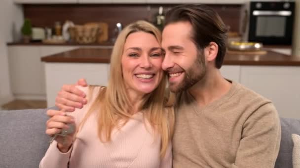 Pasangan muda menikah tersenyum riang dan menunjukkan kunci dari apartemen baru — Stok Video