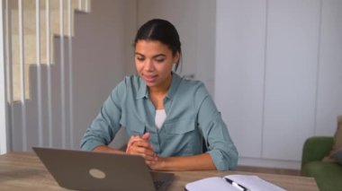 Genç pozitif kadın lapto kullanarak video iletişimi kuruyor.